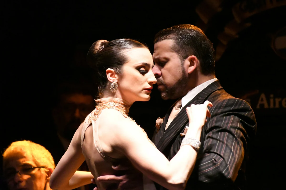 Ein Tango-Paar in enger Tanzhaltung bei einer Bühnenvorstellung im La Ventana in Buenos Aires.