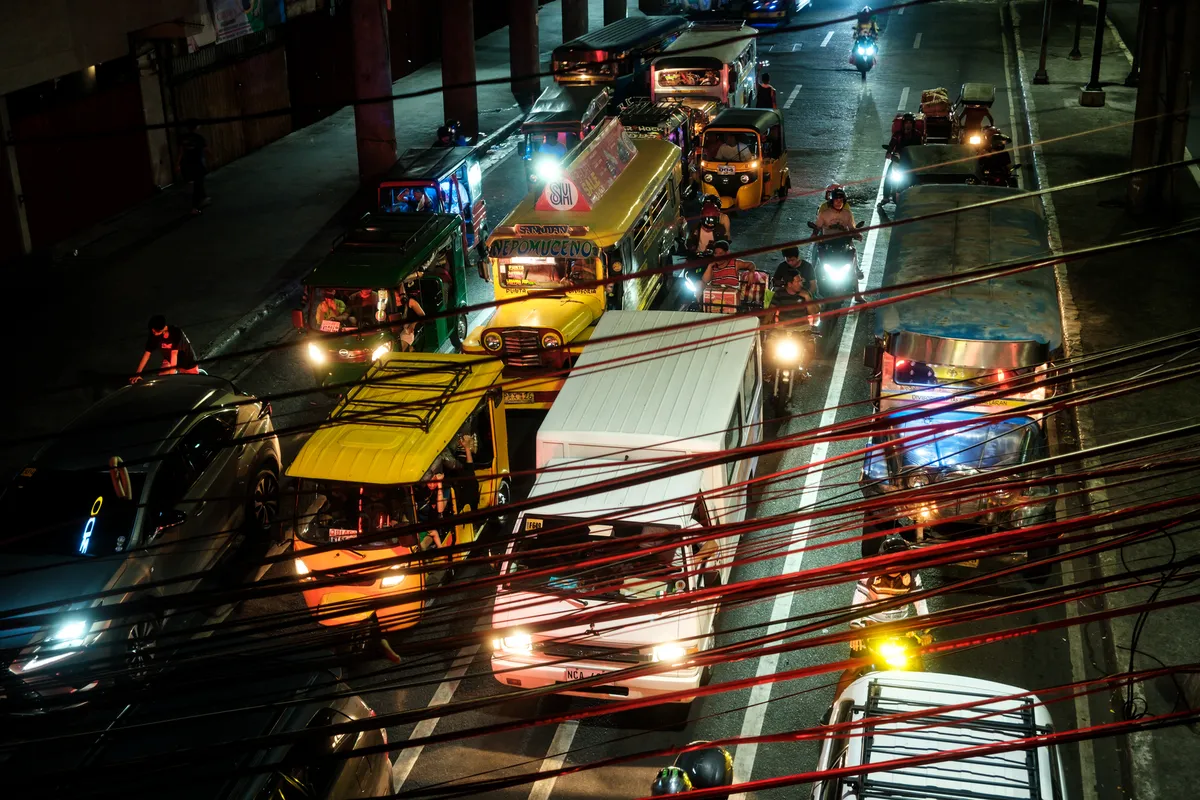 Blick von einer Brücke auf Fahrzeuge in Manila bei Nacht