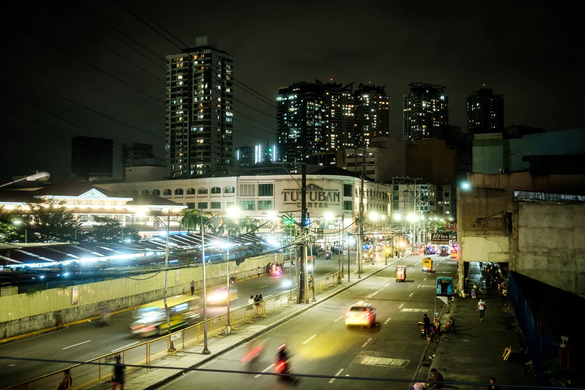 Blick von einer Brücke aus auf den Tutuban Shopping Center in Manila bei Nacht