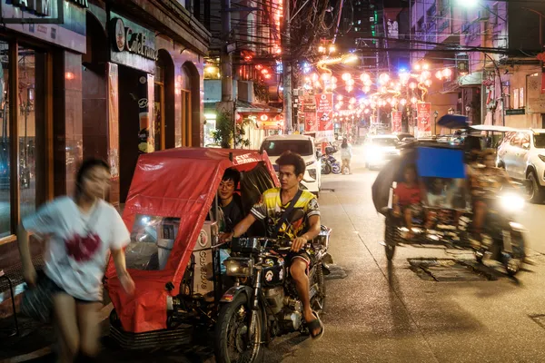 Motorradtaxifahrer bei Nacht in der Chinatown von Manila